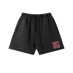 Black cotton graphic shorts — front, PM smiley framed in a small pink square on the hip