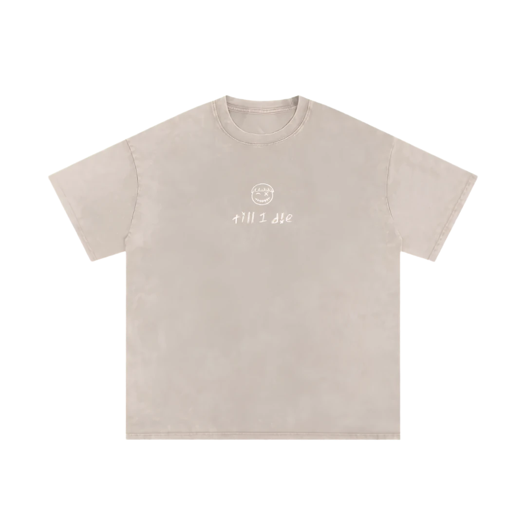 Pale apricot final cut tee — front, PM smiley and "till i die" script on the chest