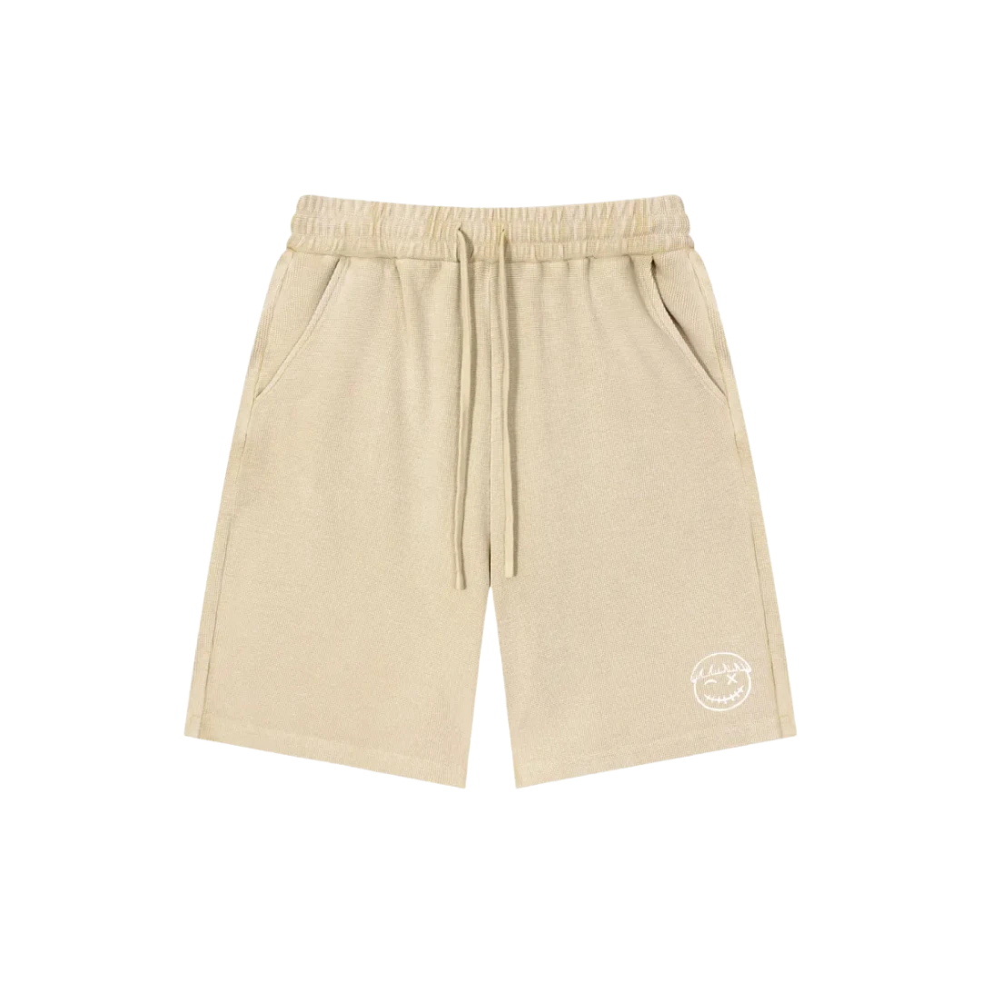 Safari sand snow wash shorts — front, tonal PM smiley patch on the hip